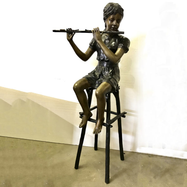Bronze statue of children sitting on chairs playing flute