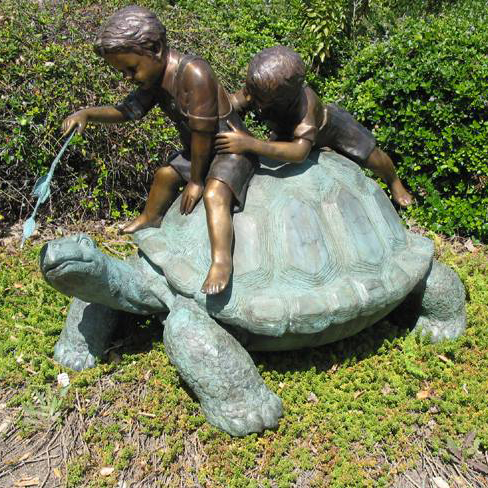 Bronze boy statues sitting on tortoise sculpture